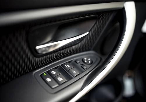 car interior details of door handle with windows controls and adjustments. Car window controls and details